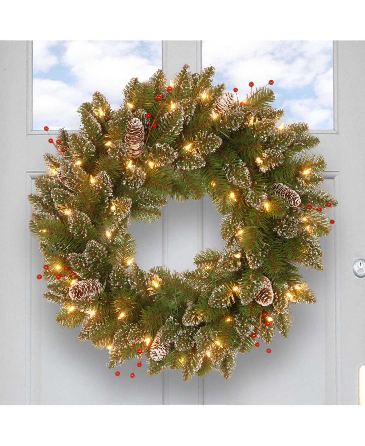 National Tree Glittery Mountain Spruce Wreath with White Edged Cones, Red Berries and 50 Warm White Battery Operated Led Lights with Timer