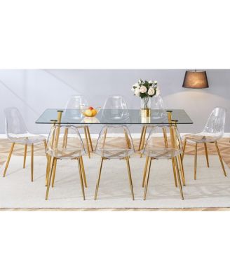 Table and chair set.Modern rectangular glass dining table with tempered glass countertop and golden metal legs, paired with multiple transparent high-quality PET dining chairs with golden legs.