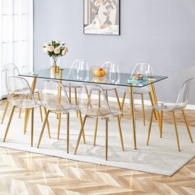 Table and chair set.Modern rectangular glass dining table with tempered glass countertop and golden metal legs, paired with multiple transparent high-quality PET dining chairs with golden legs.