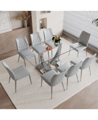 Table and chair set.Contemporary, minimalist rectangular dining table featuring a clear tempered glass top and sleek silver legs. Paired with chairs made of PU material cushion and silver metal legs.