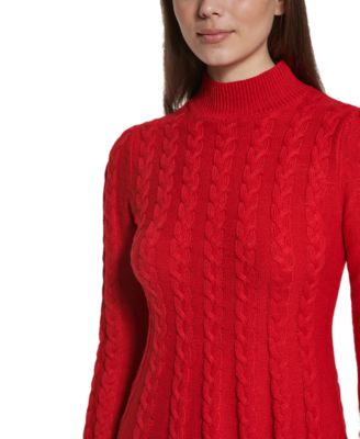 Une chemise rouge avec une étiquette blanche sur elle est posée sur une surface noire | Image