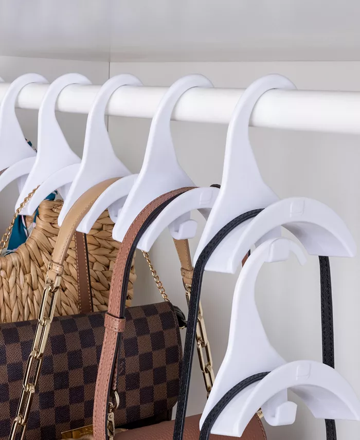 Six white purse hangers with purses on them