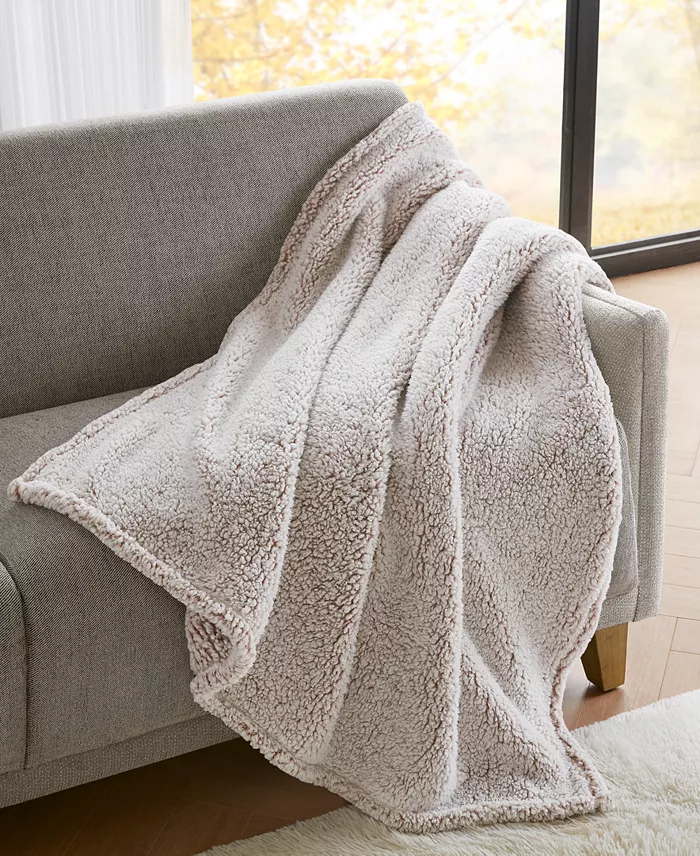 A tan sherpa blanket on a couch