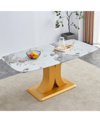 A modern minimalist dining table. Imitation marbled glass tabletop. Gold MDF table legs for kitchen and living room