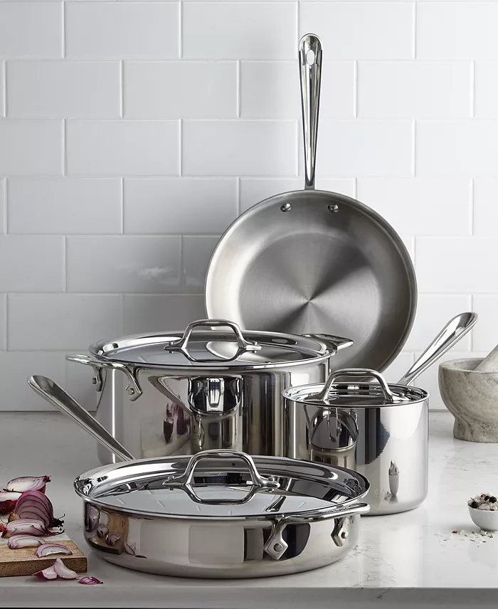 Four stainless steel pots and pans on a counter