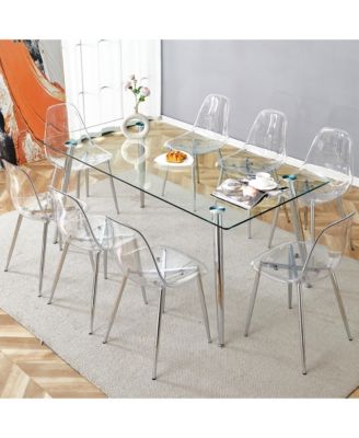 Table and chair set.Modern rectangular glass dining table with tempered glass countertop and silver metal legs, paired with multiple transparent high-quality PET dining chairs with silver legs.