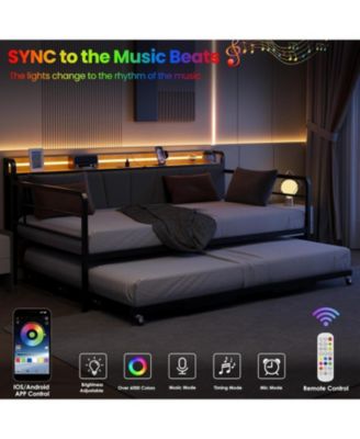 "Metal twin daybed with trundle, LED lights, upholstered headboard, and charging station."