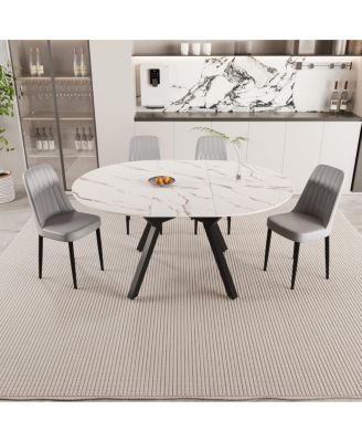 Expandable circular dining table set with 4 cushioned chairs.