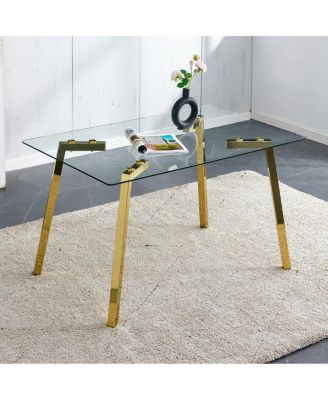 Modern minimalist rectangular glass dining table with golden metal legs.