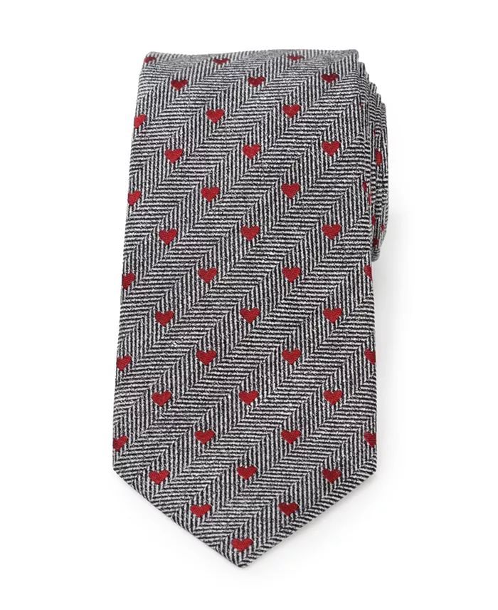 A gray herringbone tie with a red heart pattern