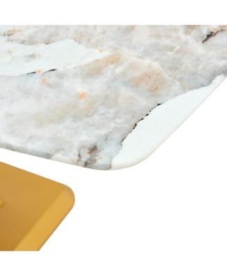 A modern minimalist dining table. Imitation marbled glass tabletop. Gold MDF table legs for kitchen and living room