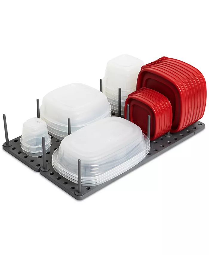 A grey pegboard organizer with clear tupperware and red tupperware lids on it