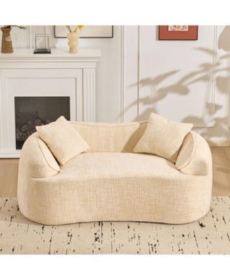 Beige curved two-person compress sofa with armrests and two pillows.